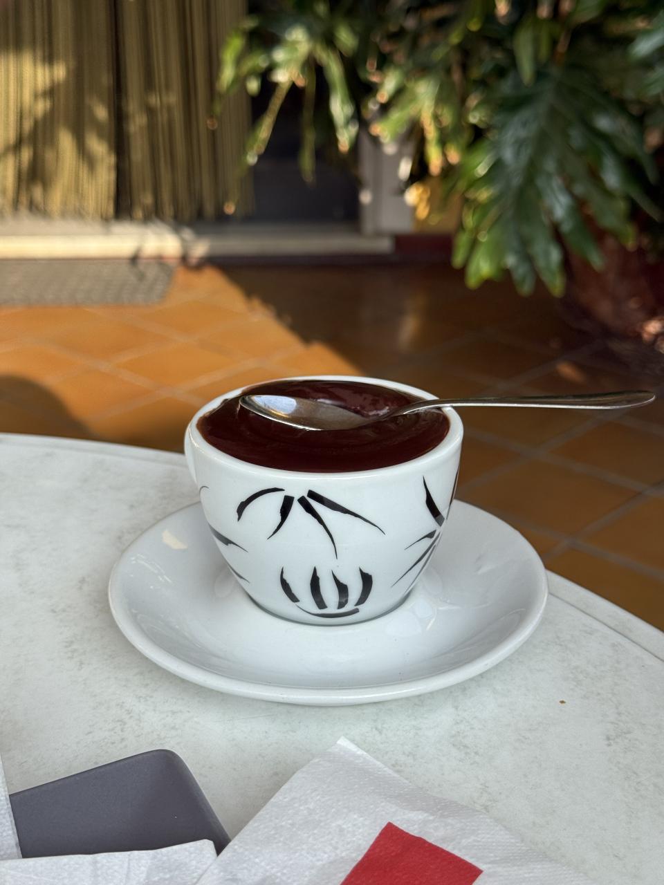 chocolat chaud dans une tasse avec une petite cuillère posée dessus qui tient 
