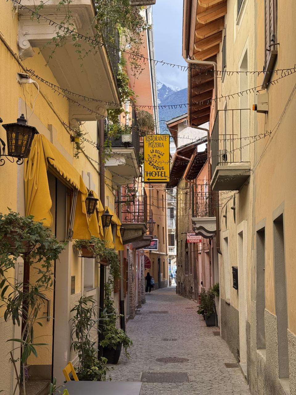petite ruelle avec des couleurs chaudes principalement jaunes. Et une enseigne d'hôtel accrochée au mur