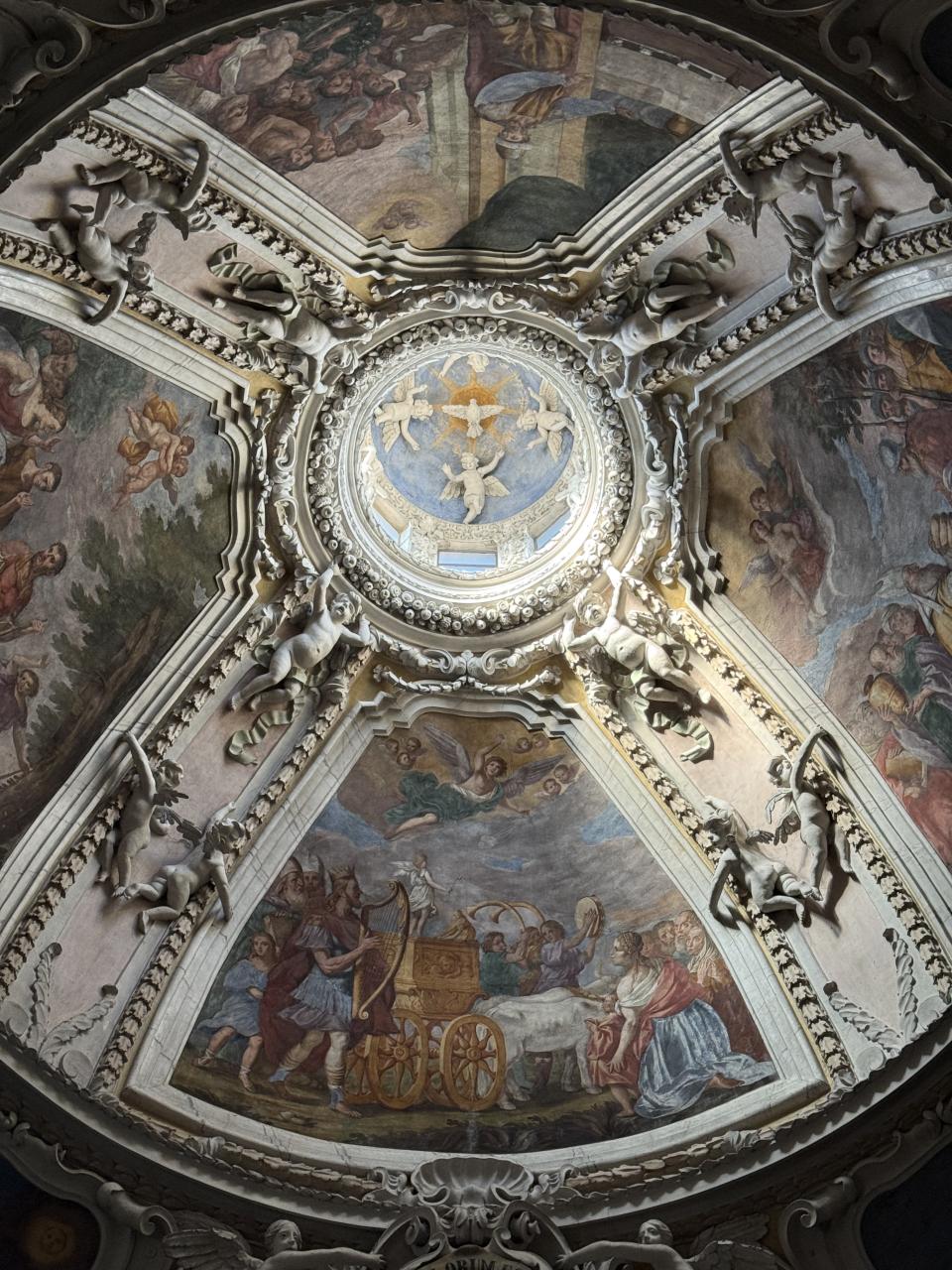 zoom vu de l'intérieur sur la coupole d'une église, on voit les anges et d'autres peintures