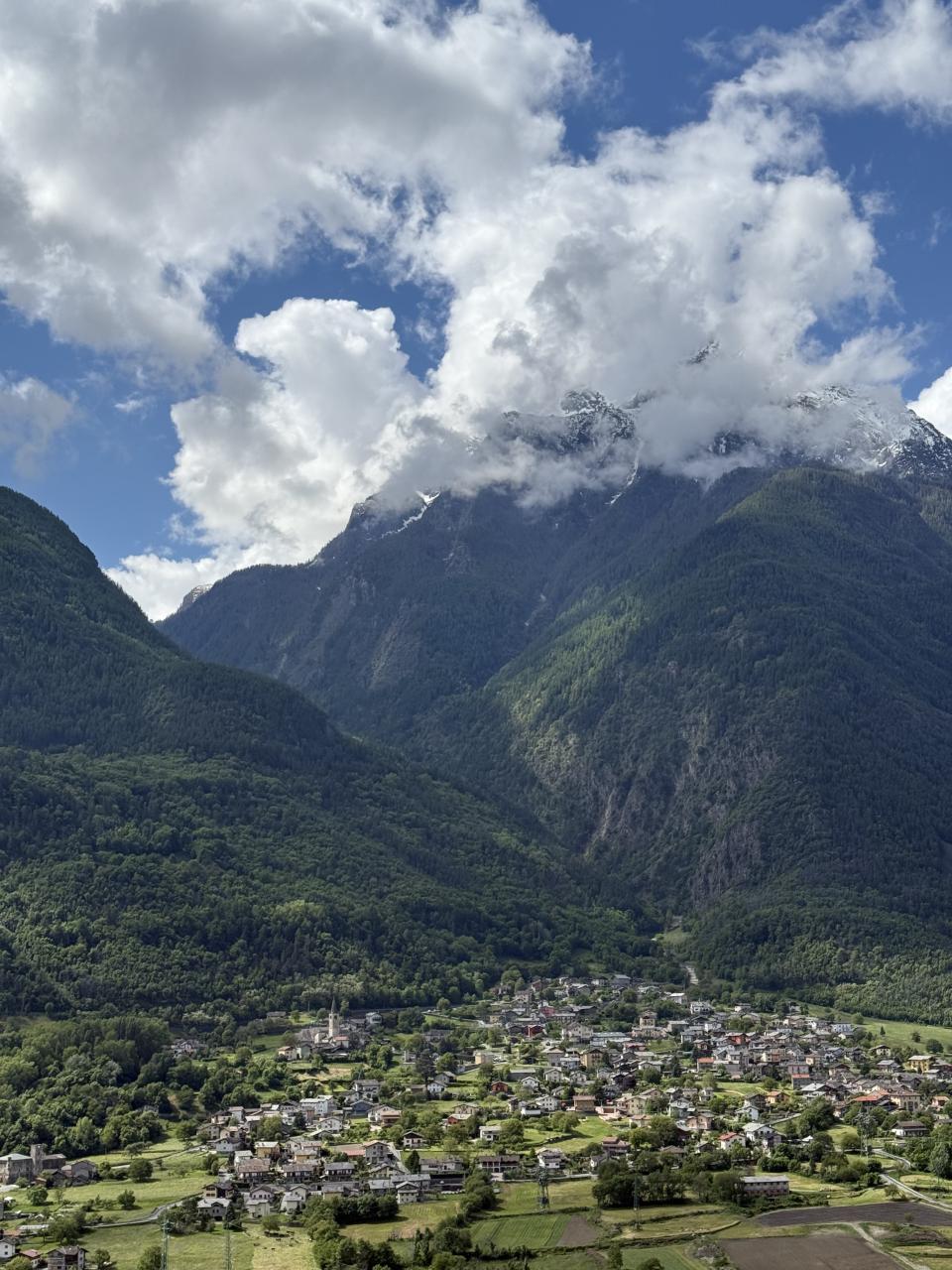 La vallée vue de haut avec une ville en bas et des montagnes de forêt qui ferment la vallée 