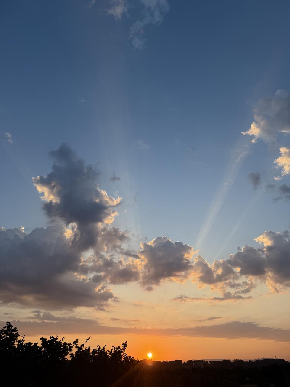 levé de soleil avec des raies de lumière passant par dessus un nuage