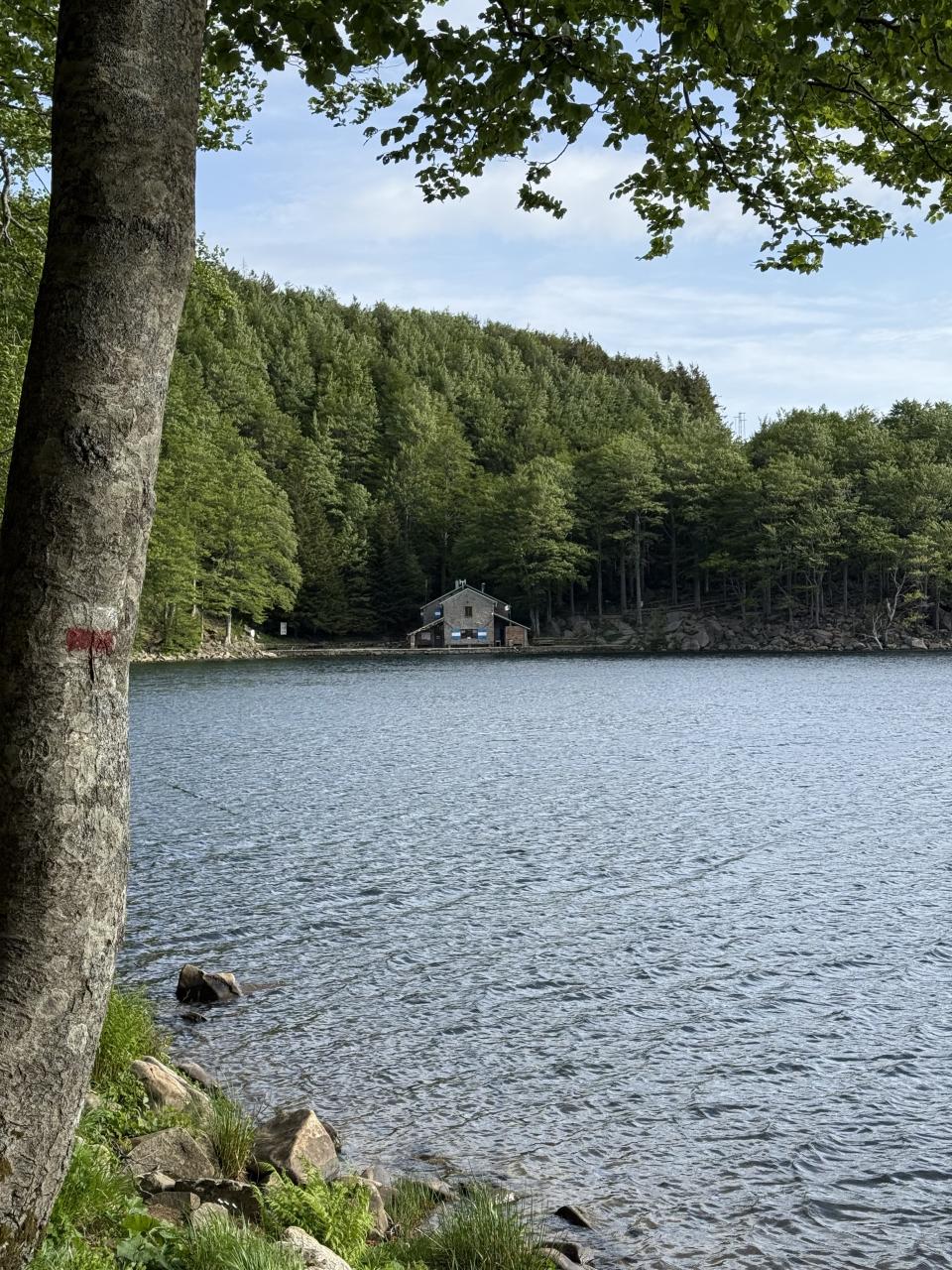 refuge en pierre au loin au bord d'un lac