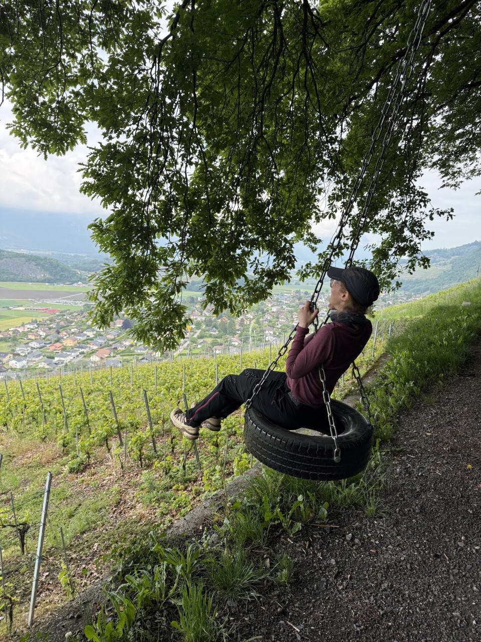 Nathalie sur un pneu qui sert de balançoire le tout face aux vignes